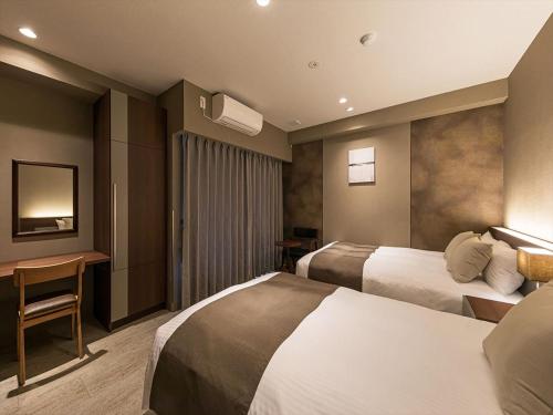 Ліжко або ліжка в номері HOTEL SHINPOIN OSAKA