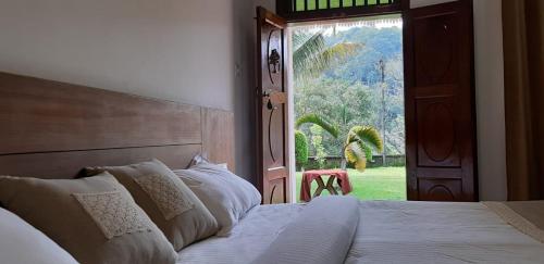 1 dormitorio con cama, ventana y puerta en Cassells Jungle Resorts Thekkady, en Vandiperiyār