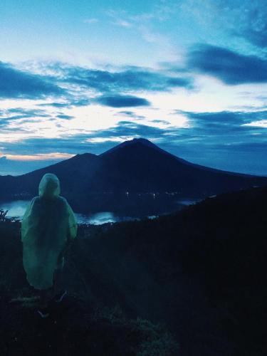 a person sitting on top of a mountain at dusk at Volcano Living in Kintamani