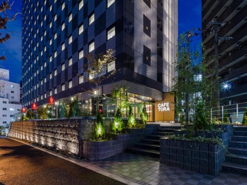 a building with stairs and trees in front of it at APA Hotel Yamanote Otsuka Ekimae Tower in Tokyo