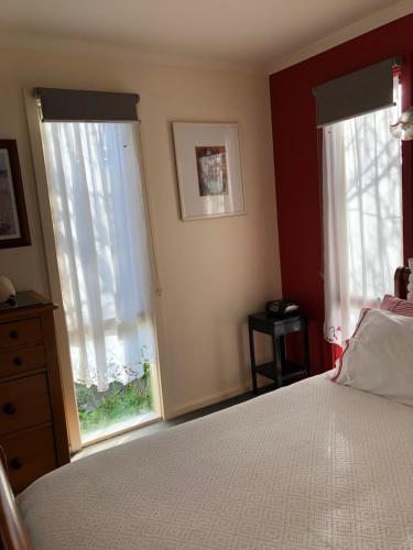 a bedroom with a bed and two windows at At the Gallery in Torquay