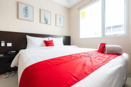 a bedroom with a large red blanket on a bed at RedDoorz Plus At Harvest Inn Panakkukang in Pampang