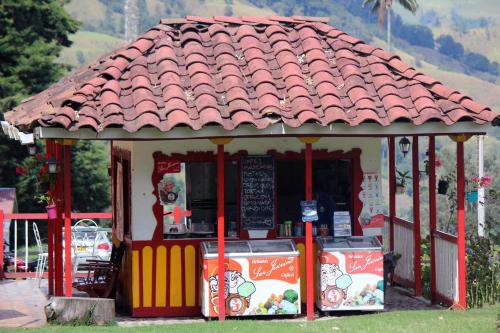 a small food cart with a red roof at Refugio Nidos del Condor Cocora in Salento