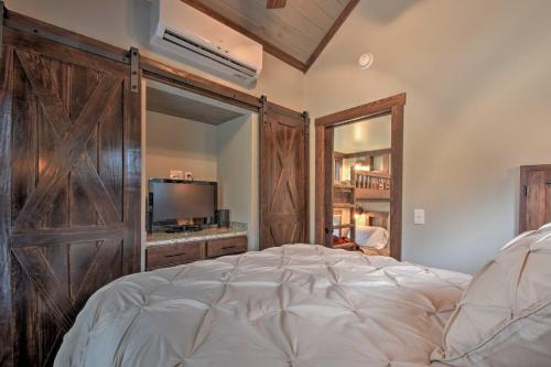 MorgantonにあるSecluded Morganton Tiny Home with Hot Tub Access!のベッドルーム1室(大型ベッド1台、大きな木製ドア付)