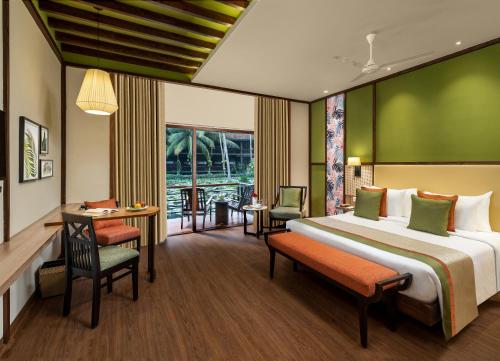 a hotel room with a bed and a table and chairs at RVR Sarovar Portico in Rāzole