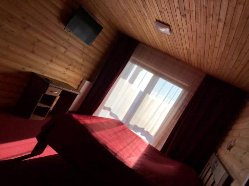 a bedroom with a red bed and a window at Глухомань Аквапарк in Poltava