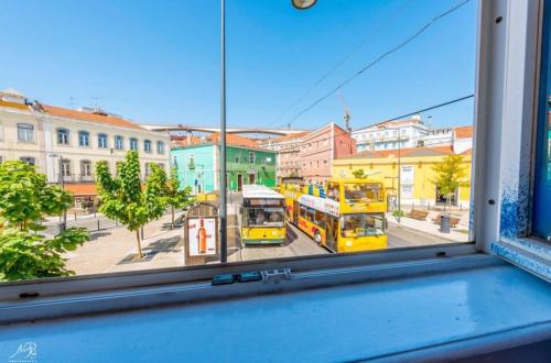 two buses are parked outside of a window at SwissLisbon Guest House in Lisbon