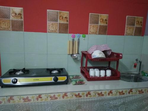 uma cozinha de brinquedo com um fogão e um lavatório em Bonda Guesthouse II em Paka