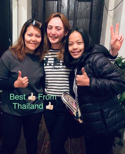 three women posing for a picture with a best from thailand sign at Butichi Guest House in Chiatʼura