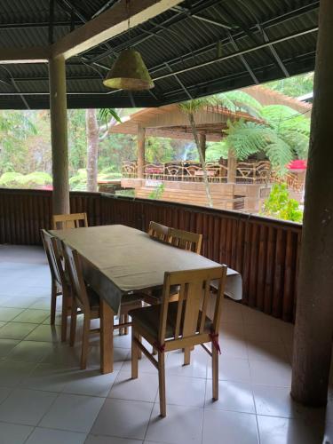 a table and chairs on a patio with a table and a porch at Pulangbato Falls Mountain Resort in Dumaguete