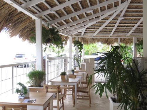 un patio esterno con tavoli, sedie e piante di Corales Punta Cana a Punta Cana