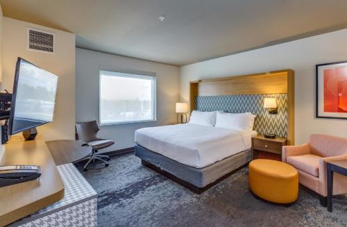 a hotel room with a bed and a desk and a computer at Holiday Inn & Suites Bellingham by IHG in Bellingham