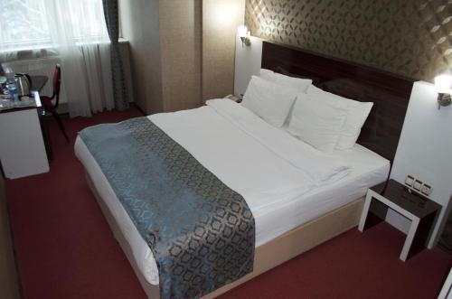 a hotel room with a large bed with white sheets at Anya Suit Otel in Denizli