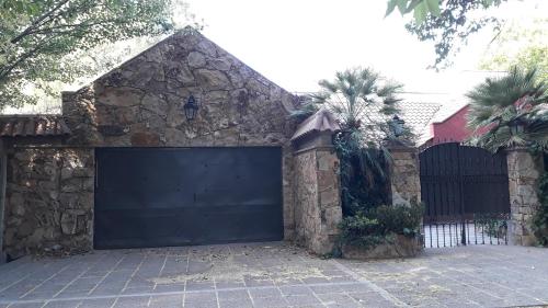 a garage with a black garage door on a house at La casita en el parque in Chacras de Coria