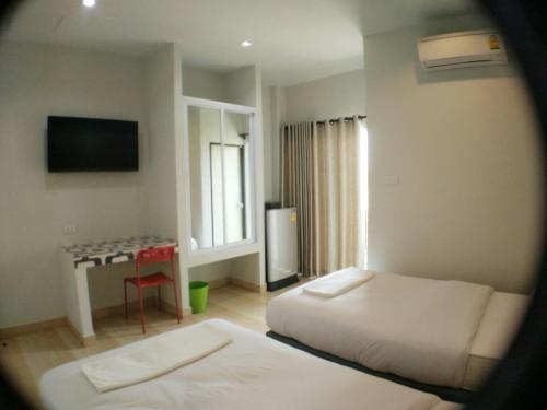 een hotelkamer met 2 bedden en een tafel bij R.M.Mansin.Surin. in Surin