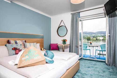 ein Hotelzimmer mit einem Bett und einem Balkon in der Unterkunft Best In Hosting Beach House Velden in Velden am Wörthersee