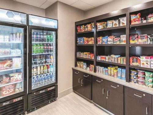 a grocery store aisle with two large refrigerators at La Quinta Inn & Suites by Wyndham Walla Walla in Walla Walla