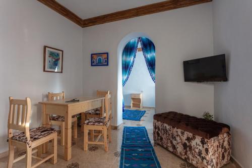 a living room with a table and a tv at Dar Sidi Mfedal in Chefchaouene