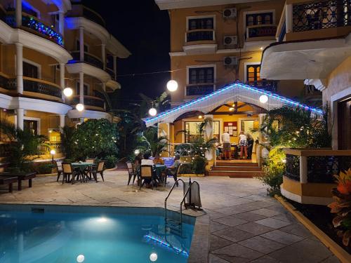 a hotel patio with a swimming pool at night at PRISTINE RESORT in Utorda
