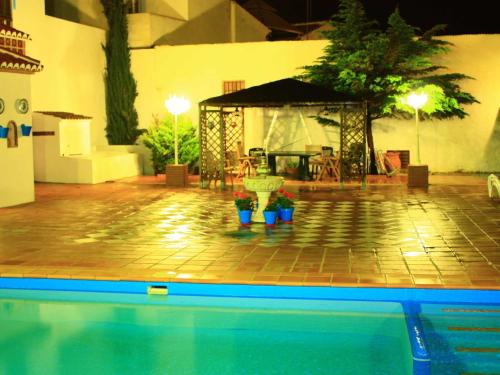 - une piscine avec un kiosque et une table dans l'établissement Belvilla by OYO La F brica de Juan, à La Joya