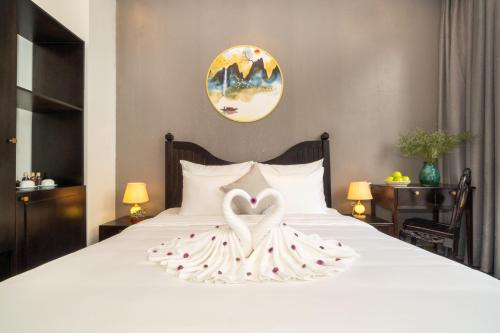 a bed with two swans made to look like hearts at Hoi An Gravel Pool Villa & Spa in Hoi An