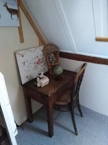 uma pequena secretária de madeira com uma cadeira e um quadro em au petit bonheur em Putanges