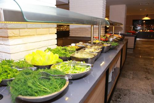 a buffet line with bowls of lettuce and vegetables at Noxinn Deluxe Hotel - Ultra All Inclusive in Konaklı