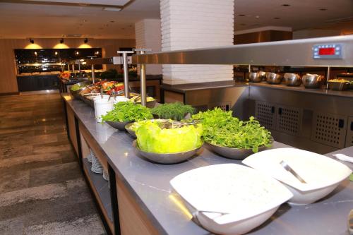 a buffet line with bowls of vegetables and toilets at Noxinn Deluxe Hotel - Ultra All Inclusive in Konaklı