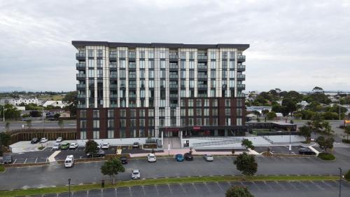 een groot gebouw met een parkeerplaats ervoor bij Ramada Suites by Wyndham Manukau in Auckland