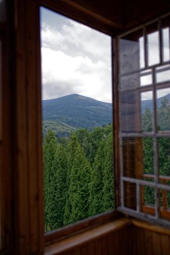 a window with a view of the woods and mountains at Zielone Wzgórze in Karpacz