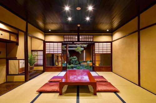 a room with a table and red mats on the floor at Campton Nishijin Vacation Rental in Kyoto