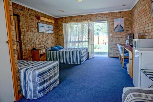 a room with a bed, a table and a window at Kadina Gateway Motor Inn in Kadina