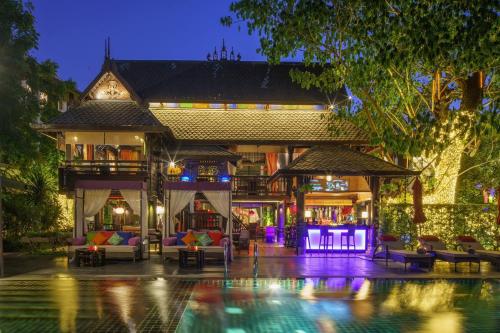 a villa with a swimming pool at night at Chala Number6 in Chiang Mai