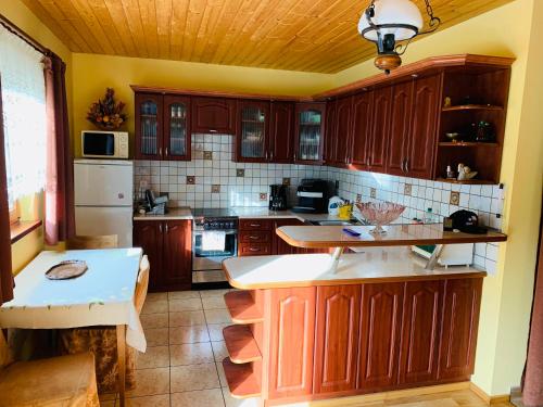 a kitchen with wooden cabinets and a white refrigerator at Dom CROCUS z ogrodem w Parku Krajobrazowym in Brenna