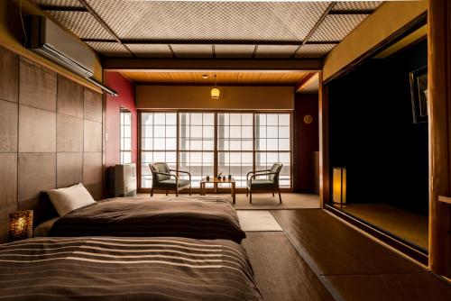 Ένα ή περισσότερα κρεβάτια σε δωμάτιο στο Takamiya Ryokan Yamakawa