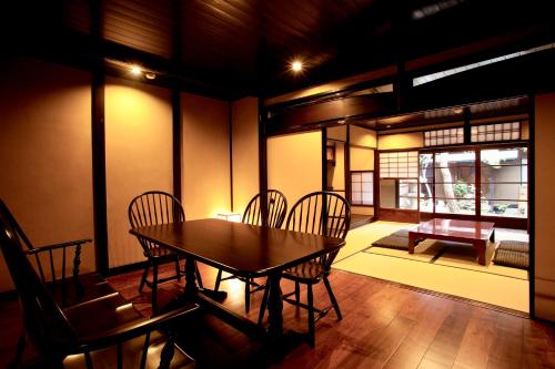 a dining room with a table and chairs and a window at Campton Nishijin Vacation Rental in Kyoto
