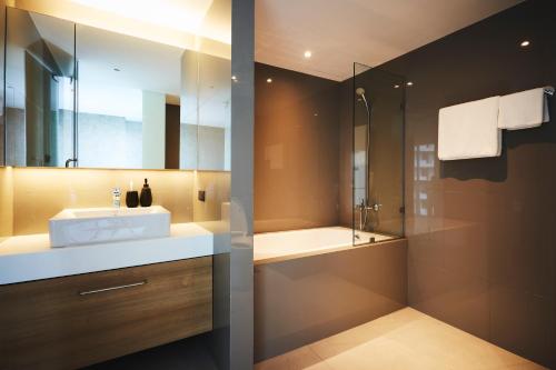 a bathroom with a sink and a shower at Aspira Tropical Residence Thong Lor in Bangkok