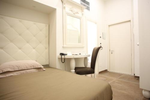 a bedroom with a bed and a desk and a window at Hotel Columbia Wellness & Spa in Montecatini Terme