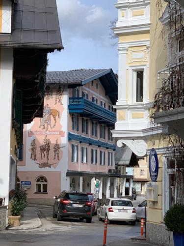 a city street with cars parked in front of buildings at Hotel Radetzky in Sankt Gilgen
