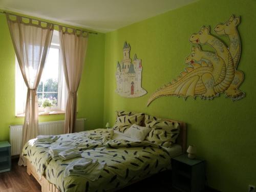 a bedroom with a bed with a dragon on the wall at Penzion Blatno in Blatno