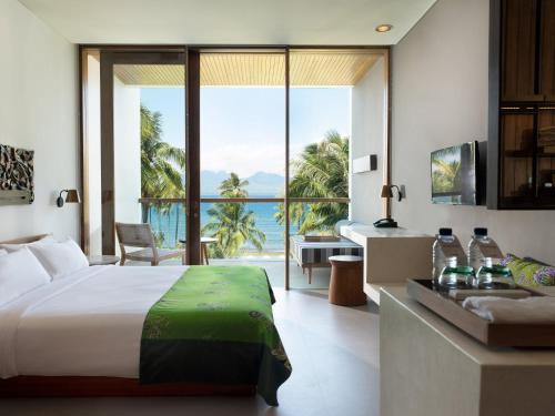 a bedroom with a bed and a view of the ocean at Dialoog Banyuwangi in Banyuwangi