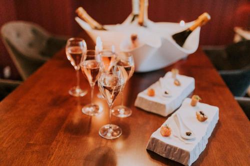 a table with wine glasses and a basket of food at Seehotel Töpferhaus in Alt Duvenstedt