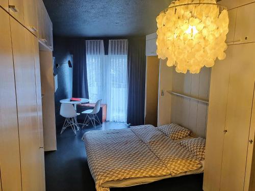 a bedroom with a bed and a chandelier at Z Studio - next door to Vals Therme in Vals