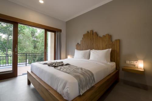 um quarto com uma cama grande e uma janela grande em Asanaya Suites em Canggu