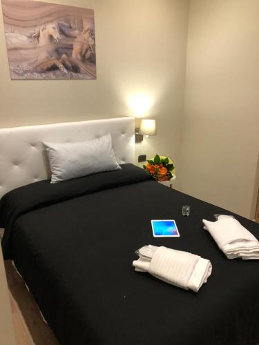 a bed with two white pillows and a tablet on it at Trevi Portrait in Rome