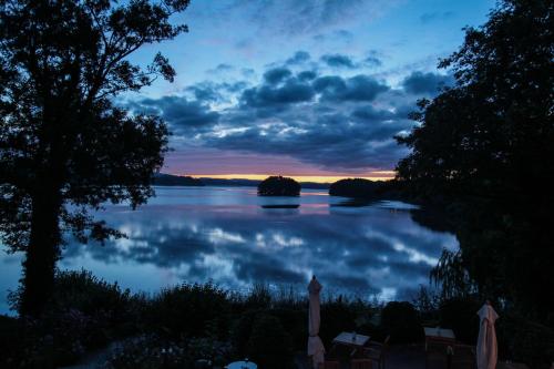 a view of a body of water at sunset at Seehotel Töpferhaus in Alt Duvenstedt