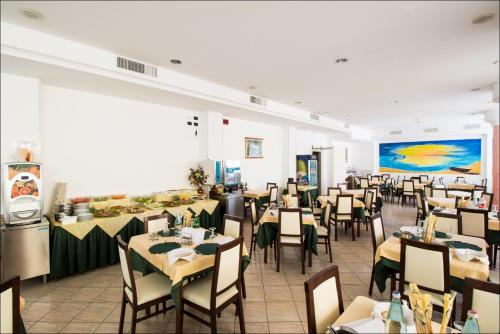 um restaurante com mesas e cadeiras num quarto em Hotel Belfiore em Misano Adriatico