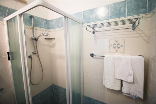 a bathroom with a shower and white towels at Hotel Belfiore in Misano Adriatico