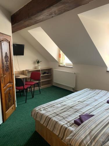 a bedroom with a bed and a table and chairs at Penzion U Orla in Petříkov