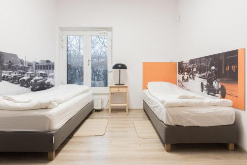 two beds in a room with a picture of cars at Dom gościnny Luk Luk in Sopot